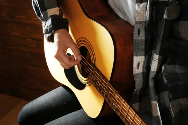 Guitarist plays guitar on wooden background, close up — Stock Photo, Image