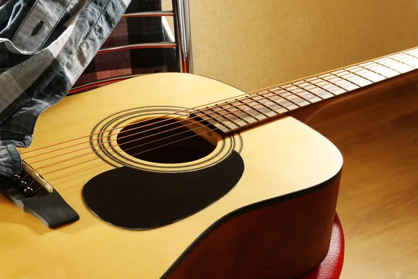 Akustická kytara na červenou stolici v ateliéru, zblízka — Stock fotografie