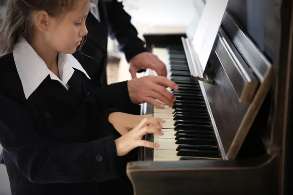 Professeur trains pour jouer piano fille — Photo