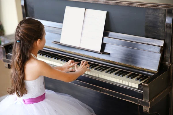 Prinses meisje speelt piano — Stockfoto