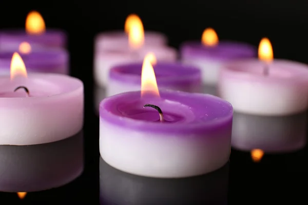 Molte piccole candele accese su sfondo scuro, primo piano — Foto Stock