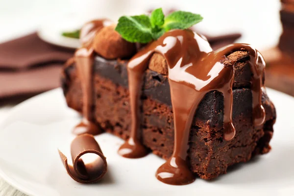 Кусок шоколадного торта с мятой на столе, крупным планом — стоковое фото