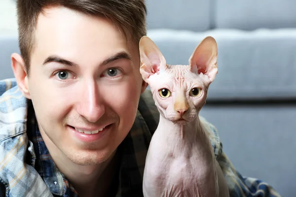 Handsome man lies with cat on floor — Stock Photo, Image