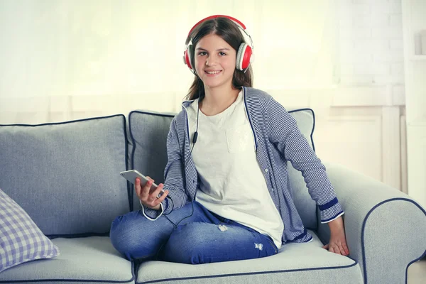 Όμορφο κορίτσι να ακούτε μουσική στον καναπέ — Φωτογραφία Αρχείου