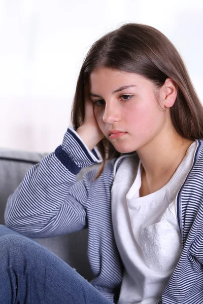 Kanepede oturan üzgün kız — Stok fotoğraf