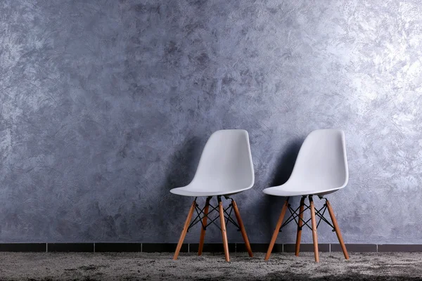 Stijlvol ontwerp met twee witte stoelen op grijze achtergrond — Stockfoto