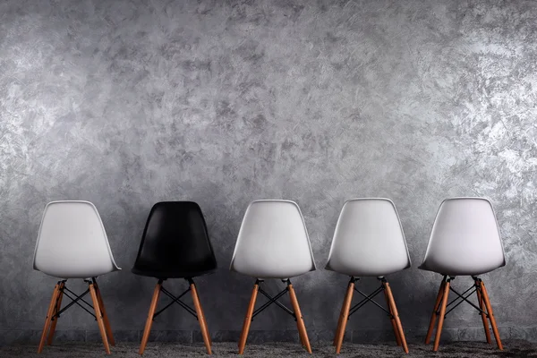Concepção elegante com cadeiras brancas e pretas sobre fundo cinza — Fotografia de Stock