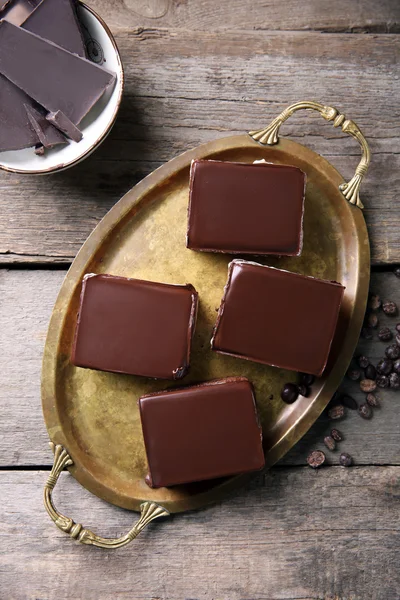 Delicious chocolate brownies on tray, on wooden background — Stock Photo, Image