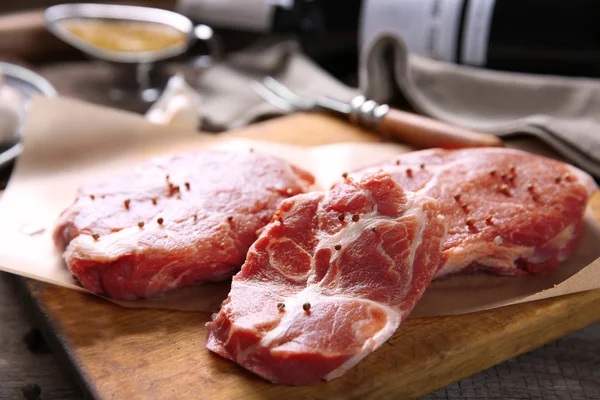 Filete de res de mármol con botella de vino y especias sobre fondo de madera — Foto de Stock