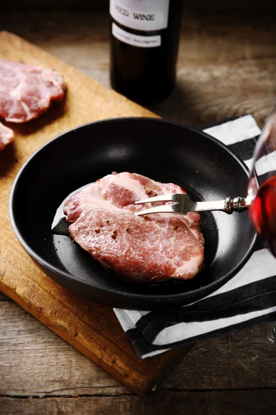 Steak de boeuf marbré et bouteille de vin sur fond en bois — Photo