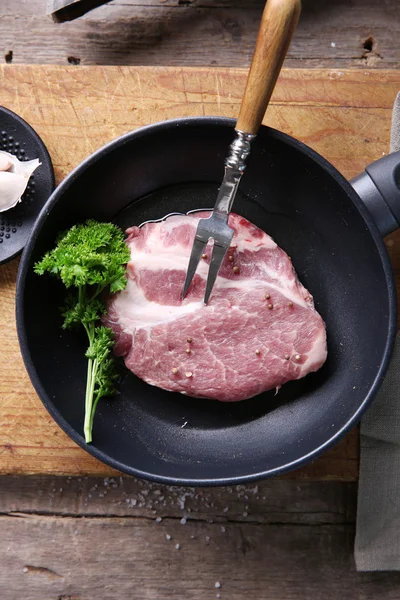 Steak de bœuf marbré sur poêle et épices sur fond bois — Photo