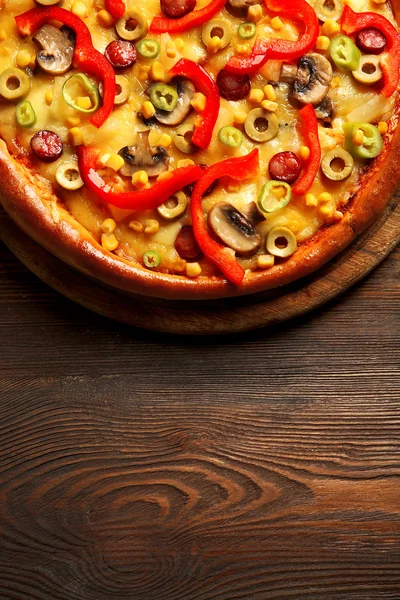 Delicious pizza with vegetables on wooden table — Stock Photo, Image