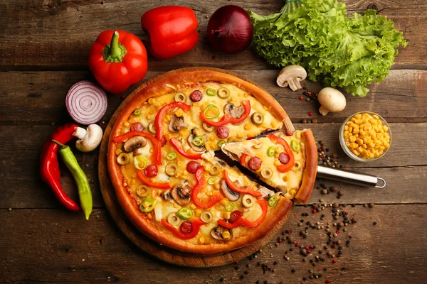 Pizza deliciosa com legumes e fatia na pá, close-up — Fotografia de Stock