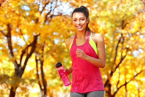 Mujer corriendo con botella de agua — Foto de Stock