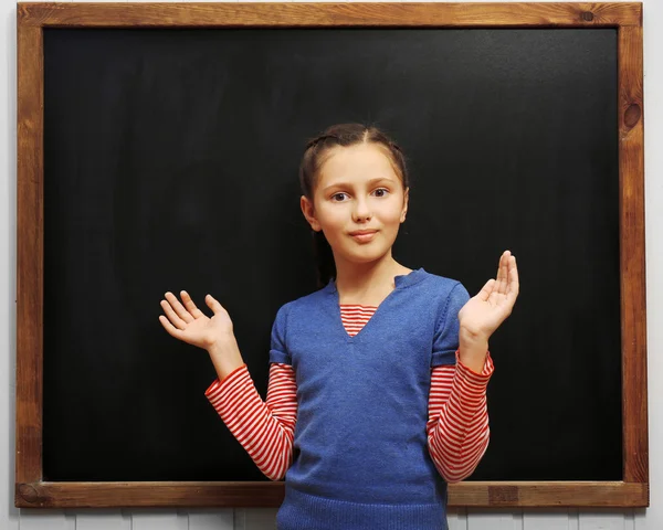 Girl posing at clean blackboard — Stock Photo, Image