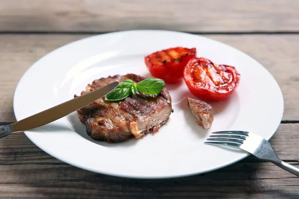 Filet de bœuf rôti sur assiette, sur fond bois — Photo