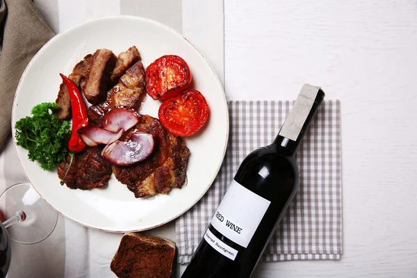 Filete de ternera asada y verduras a la parrilla en plato, sobre fondo de madera — Foto de Stock