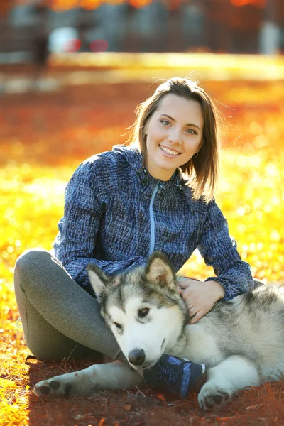 Woman sitting with her dog in park — Stock Photo, Image