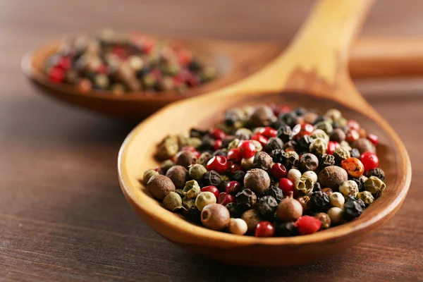 Pepper in wooden spoon on the table, close-up — Stock Photo, Image