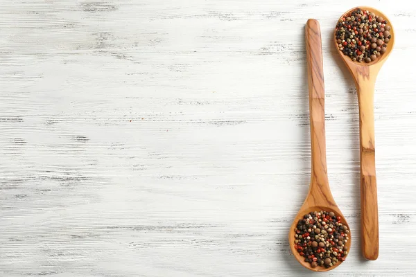 Two wooden spoons with pepper — Stock Photo, Image