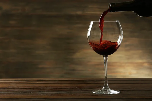 Red wine pouring in a glass — Stock Photo, Image