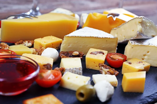 Сыр для дегустации на деревянном столе, крупным планом — стоковое фото