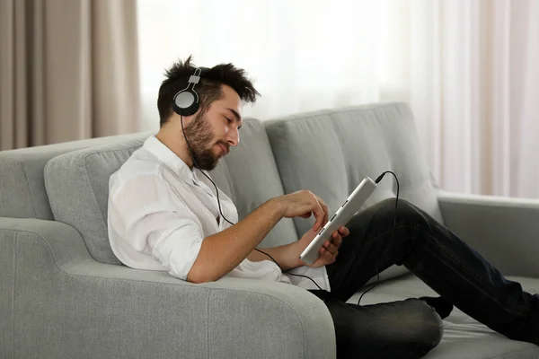 Mladý muž poslouchá hudbu se sluchátky — Stock fotografie