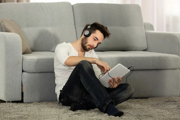 Joven escucha música con auriculares — Foto de Stock