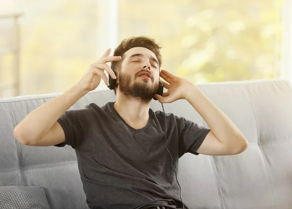 Hombre escucha música con auriculares —  Fotos de Stock