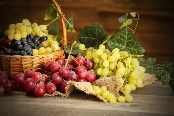 Grape in basket on wooden table — Stock Photo, Image