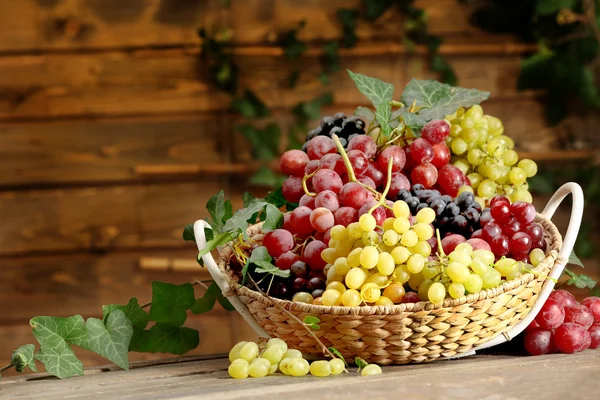 Grape in basket on wooden table — Stock Photo, Image