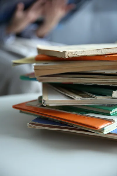 Montón de libros viejos sobre mesa blanca en la habitación. Enfoque en libros y fondo borroso —  Fotos de Stock