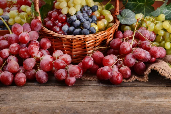 Grape in basket on wooden table — Stock Photo, Image