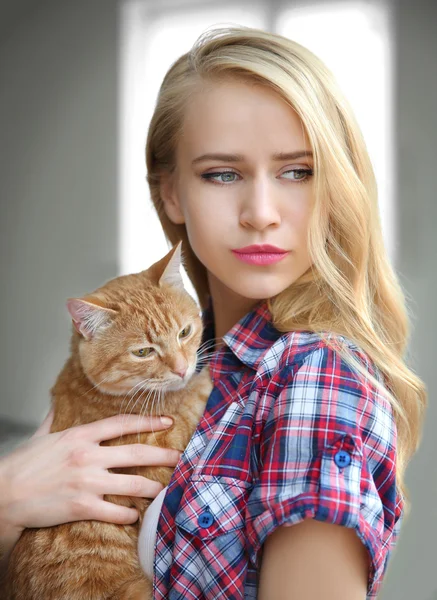 Mladá žena pózuje s červená kočka — Stock fotografie