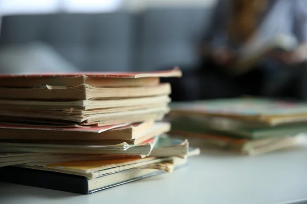 Pile of old books on white table. Focus on books and blurred background — Stock Photo, Image