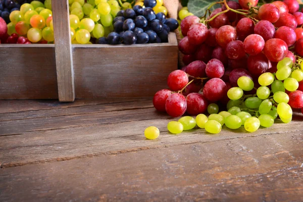 Виноград в деревянной коробке на столе — стоковое фото