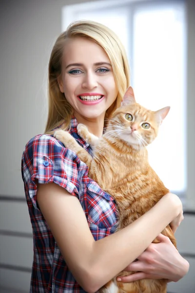 Jonge vrouw poseren met rode kat — Stockfoto