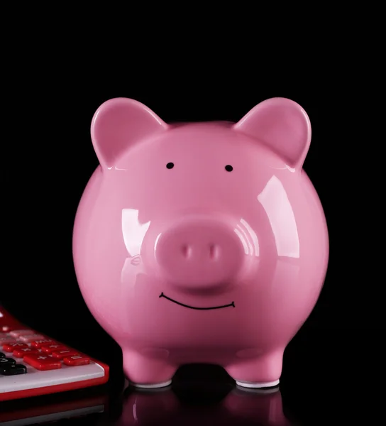 Banco porquinho com calculadora no fundo escuro — Fotografia de Stock
