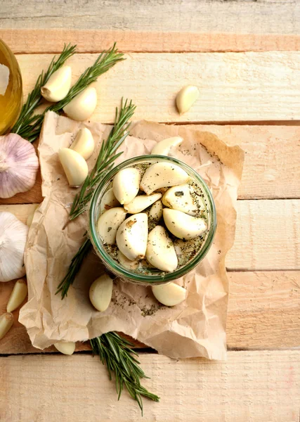 Knoflook met kruiden op houten tafel — Stockfoto