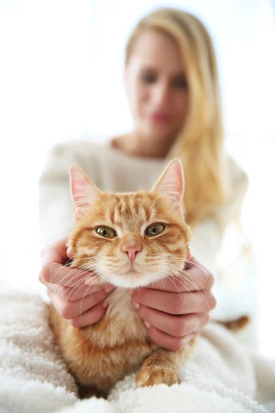 Ung kvinna poserar med röd katt — Stockfoto