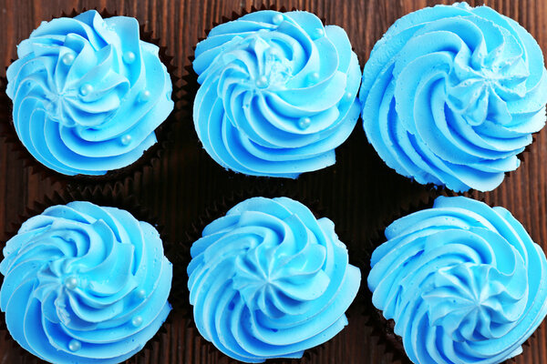 Chocolate cupcakes on wooden background, top view