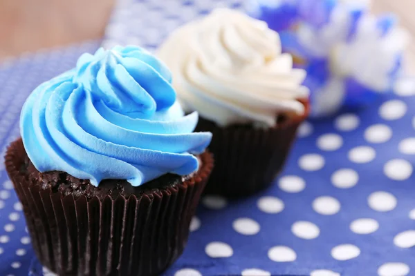 Cupcakes de chocolate y flores en servilleta, primer plano — Foto de Stock