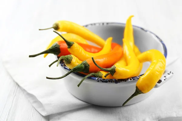 Chiles amarillos en tazón, sobre fondo de madera claro — Foto de Stock