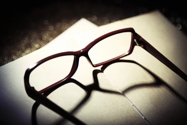 Opened book and eyeglasses on it, close up — Stock Photo, Image