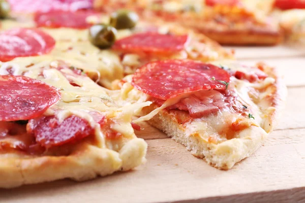 Läckra välsmakande pizza med skuren skiva, närbild — Stockfoto