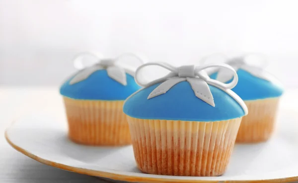 Cupcakes saborosos em stand, no fundo claro — Fotografia de Stock