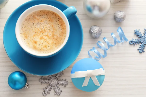 Välsmakande cupcake med båge, kaffekopp och jul leksaker på färg trä bakgrund — Stockfoto