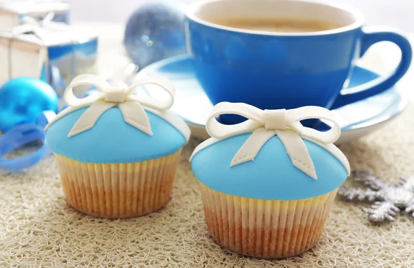 Mumsiga muffins med båge, kaffekopp och jul leksaker på färg trä bakgrund — Stockfoto