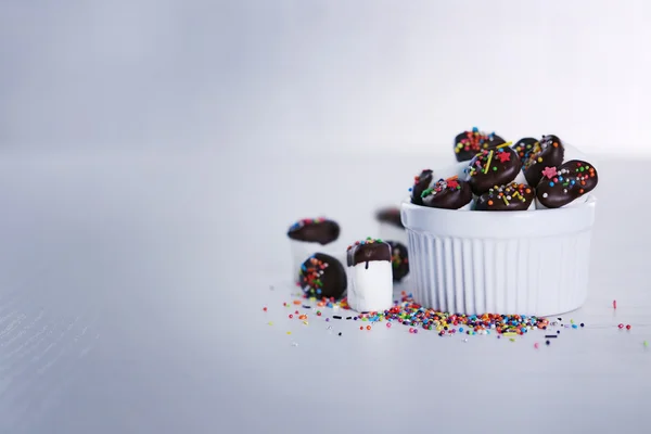 Marshmallows saborosos com chocolate na tigela na mesa, close-up — Fotografia de Stock