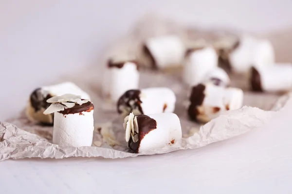 Tasty marshmallows with chocolate on paper, close up — Stock Photo, Image
